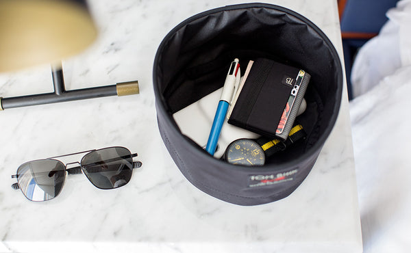A Travel Tray containing a wallet, pocket watch, pen, and hankerchief.